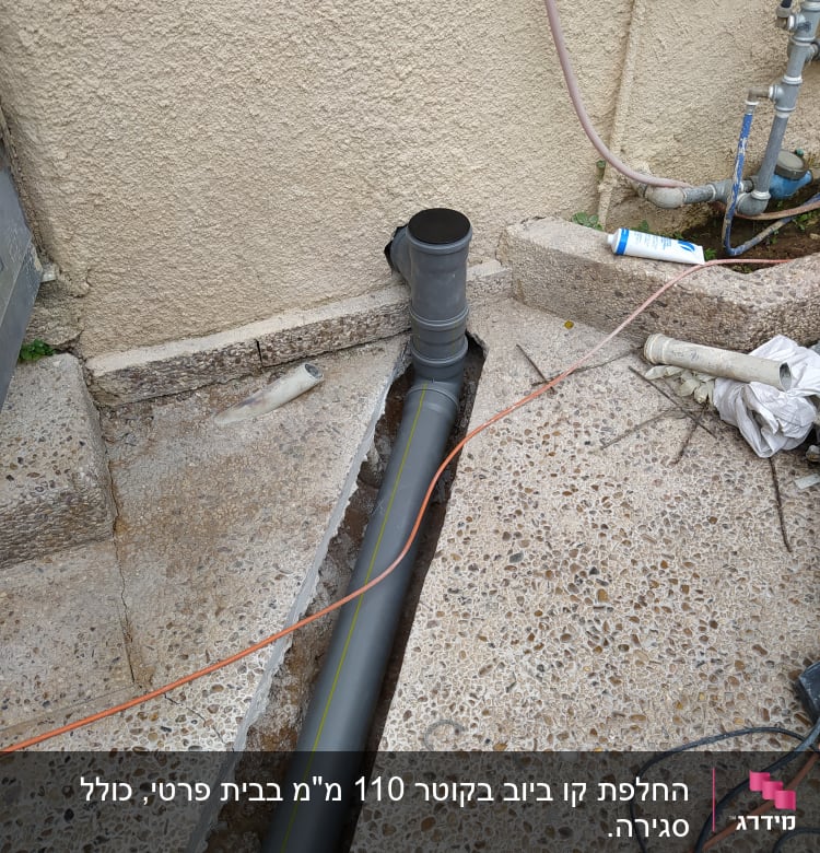 צינור פלסטיק אפור מותקן בתעלה על רצפה